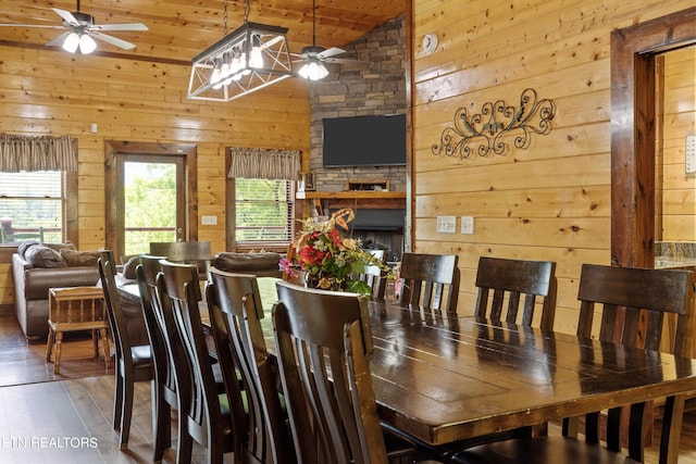 dining space featuring wooden walls, dark wood-type flooring, wood ceiling, and vaulted ceiling