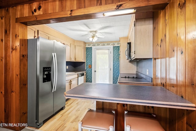 kitchen featuring wooden walls, ceiling fan, stainless steel fridge, light wood-type flooring, and dishwashing machine