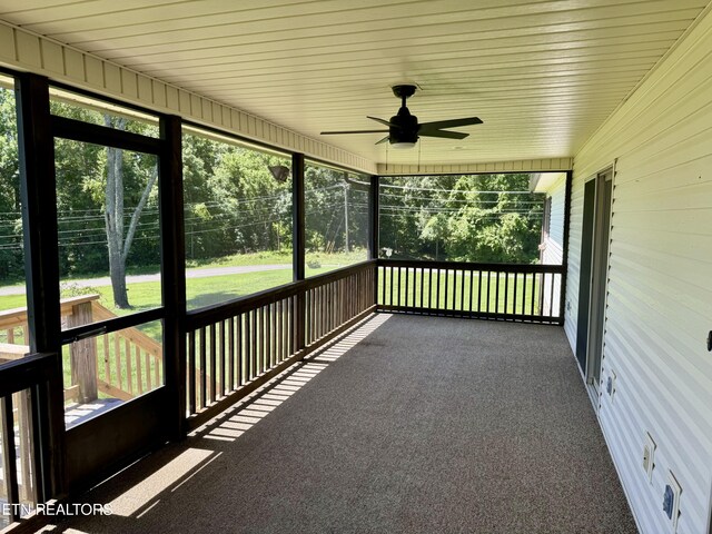 unfurnished sunroom with ceiling fan