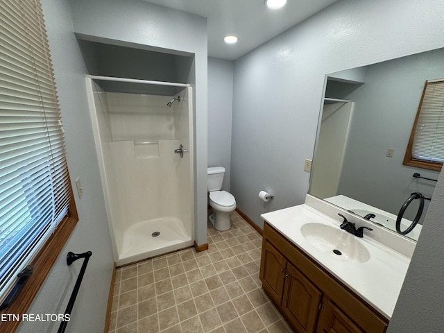 bathroom featuring a shower, vanity, and toilet