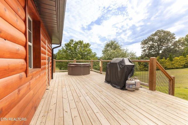 deck with grilling area and a hot tub