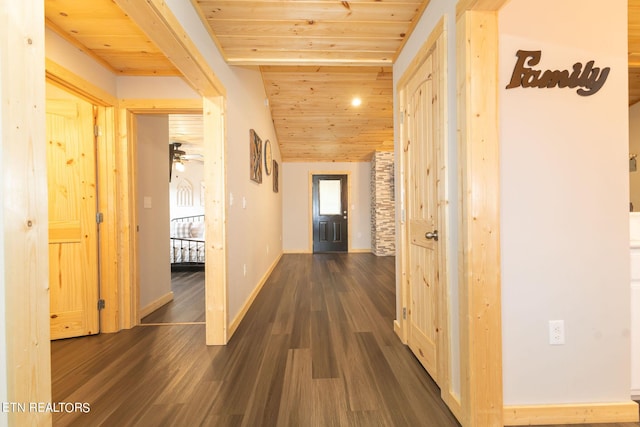 hallway with dark hardwood / wood-style floors, vaulted ceiling, and wooden ceiling