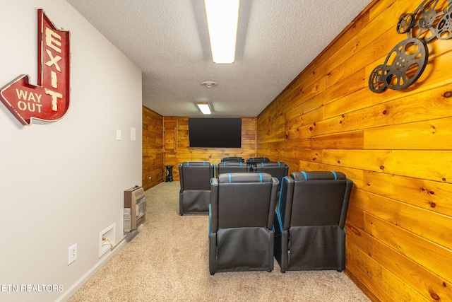 home theater featuring light carpet, a textured ceiling, and wood walls