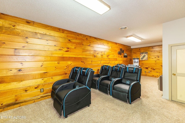 cinema room with light carpet, a textured ceiling, and wooden walls