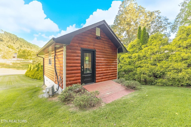 view of outbuilding with a mountain view, ac unit, and a lawn