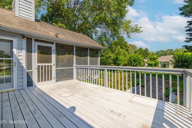 wooden deck with a sunroom