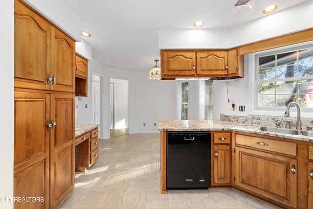 kitchen featuring pendant lighting, dishwasher, light stone countertops, and sink