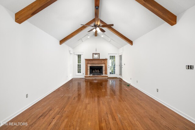 unfurnished living room featuring ceiling fan, beamed ceiling, high vaulted ceiling, hardwood / wood-style floors, and a fireplace