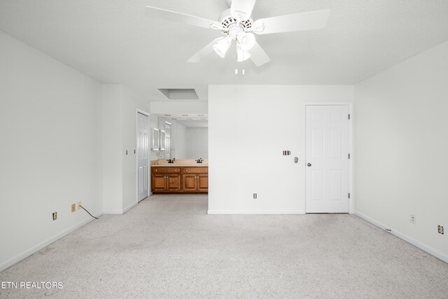 unfurnished bedroom with connected bathroom, ceiling fan, and light carpet