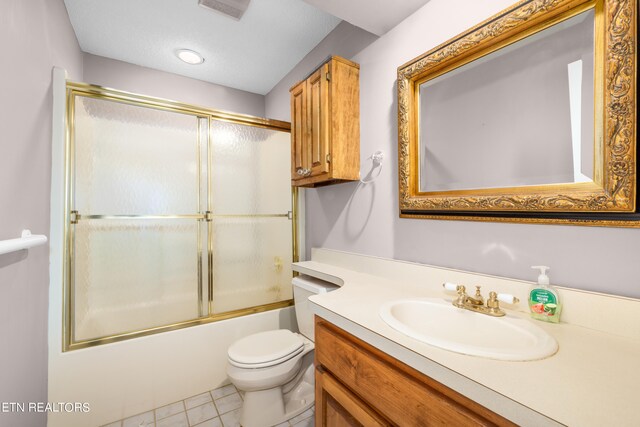 full bathroom with tile patterned floors, toilet, vanity, and combined bath / shower with glass door