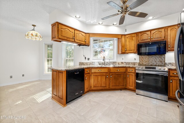 kitchen featuring black appliances, ceiling fan, light stone counters, and hanging light fixtures