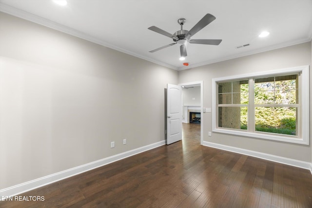 unfurnished room with crown molding, dark wood-type flooring, and ceiling fan