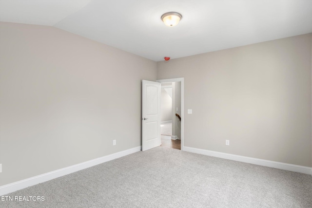 spare room featuring lofted ceiling and carpet floors