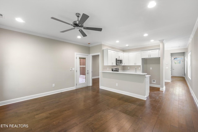 unfurnished living room featuring a wealth of natural light, ornamental molding, ceiling fan, and dark hardwood / wood-style flooring