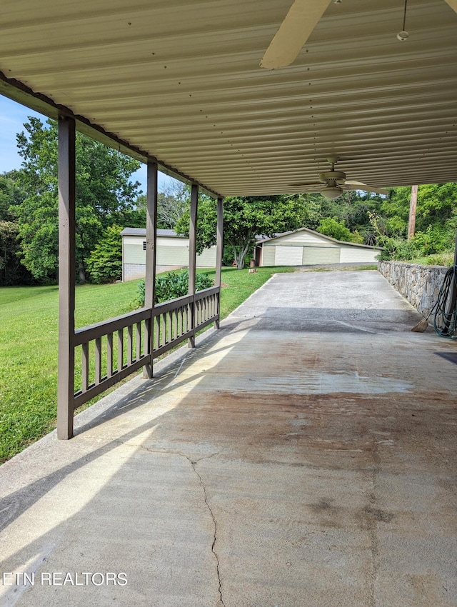 view of patio with a garage, an outbuilding, and ceiling fan