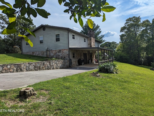 view of side of property featuring a yard and a carport