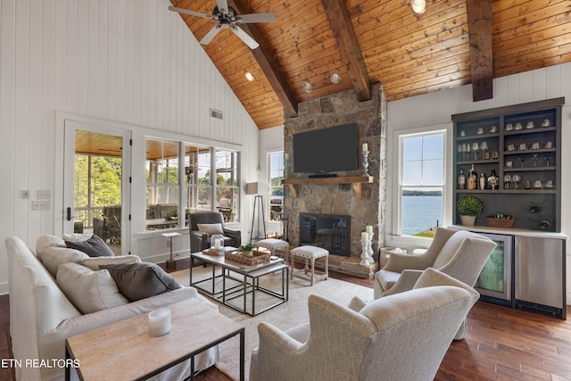 living room with beam ceiling, a stone fireplace, wooden ceiling, and high vaulted ceiling