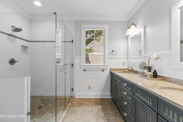 bathroom featuring vanity, ornamental molding, and tiled shower