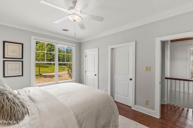 bedroom featuring ceiling fan, crown molding, and dark wood-type flooring