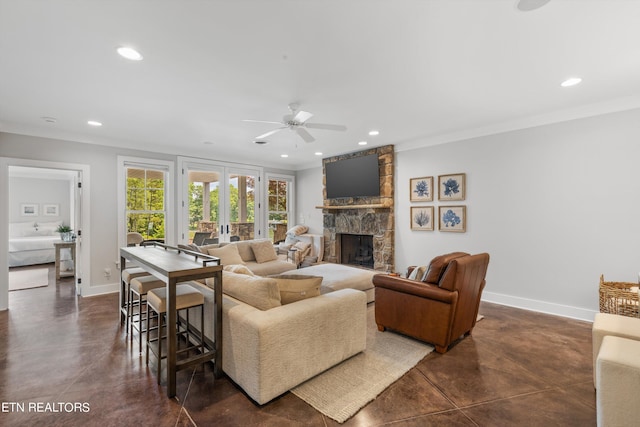 living room featuring ceiling fan, a fireplace, french doors, and ornamental molding