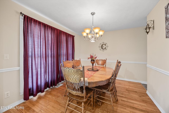 dining room featuring hardwood / wood-style floors and a chandelier