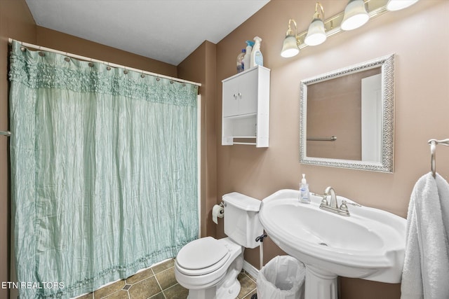 bathroom with toilet, a shower with curtain, tile patterned flooring, and sink