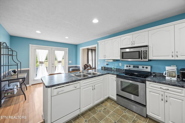 kitchen featuring sink, kitchen peninsula, white cabinets, and stainless steel appliances