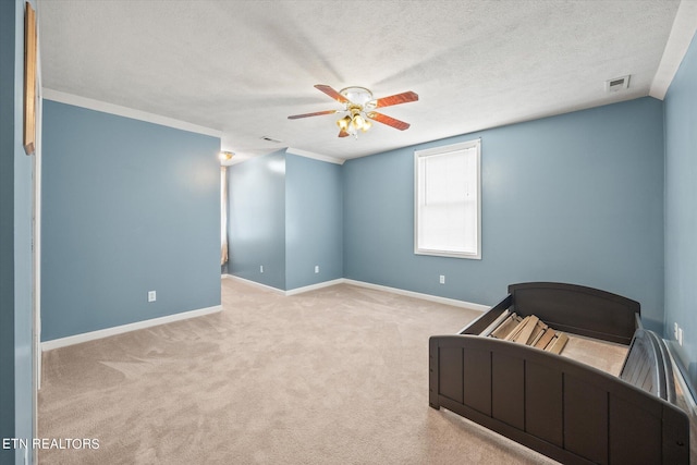 unfurnished bedroom featuring ceiling fan, a textured ceiling, and light carpet