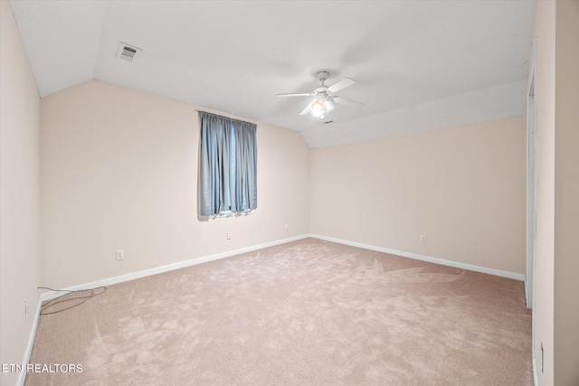 carpeted empty room with vaulted ceiling and ceiling fan