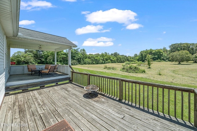 wooden terrace with an outdoor fire pit and a yard