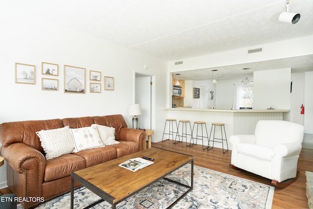 living room featuring a textured ceiling and light wood-type flooring