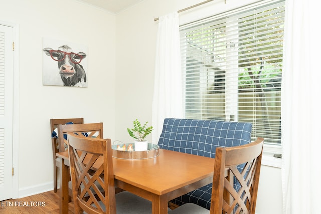 dining area with wood-type flooring and ornamental molding