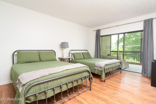 bedroom featuring access to exterior and wood-type flooring