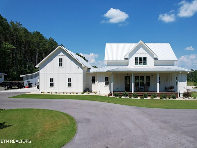 modern inspired farmhouse with a porch and a front lawn