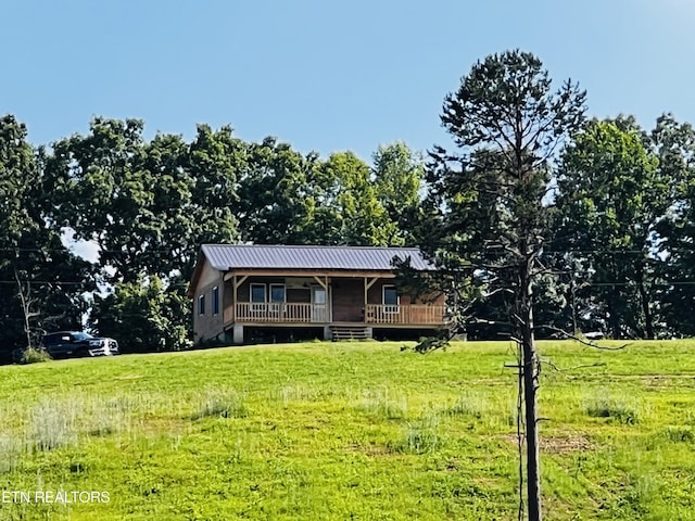 view of front facade with a deck and a front yard