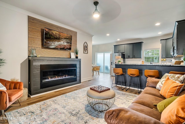 living room with ceiling fan, light hardwood / wood-style flooring, and ornamental molding