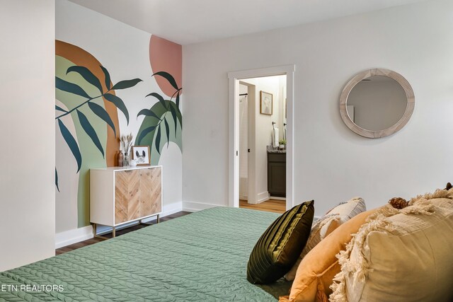 bedroom with hardwood / wood-style flooring and ensuite bath