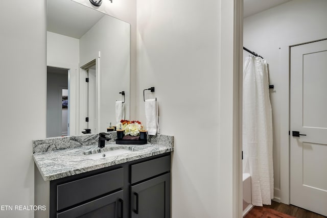 bathroom featuring wood-type flooring, vanity, and shower / bath combo with shower curtain