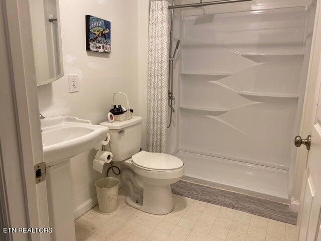 bathroom with curtained shower and toilet