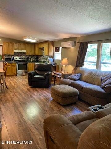 living room with an AC wall unit and hardwood / wood-style flooring