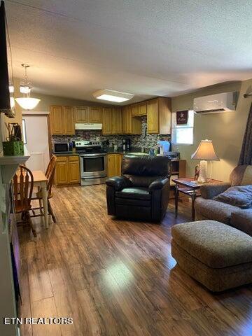 living room with wood-type flooring and an AC wall unit