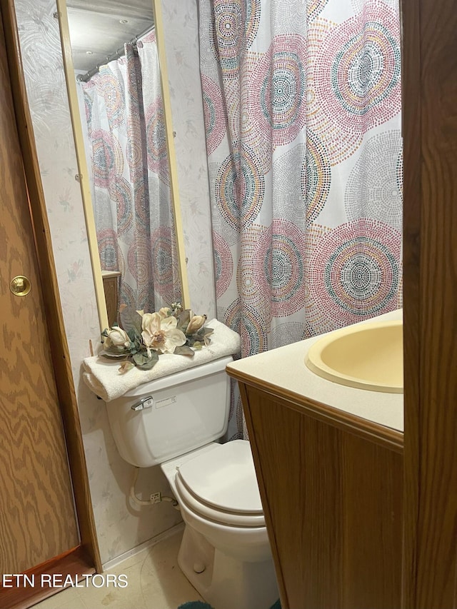 bathroom featuring toilet, vanity, and tile patterned flooring