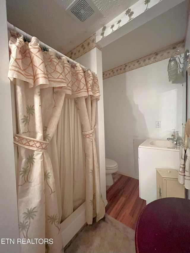 bathroom with toilet, vanity, a shower with curtain, and hardwood / wood-style floors