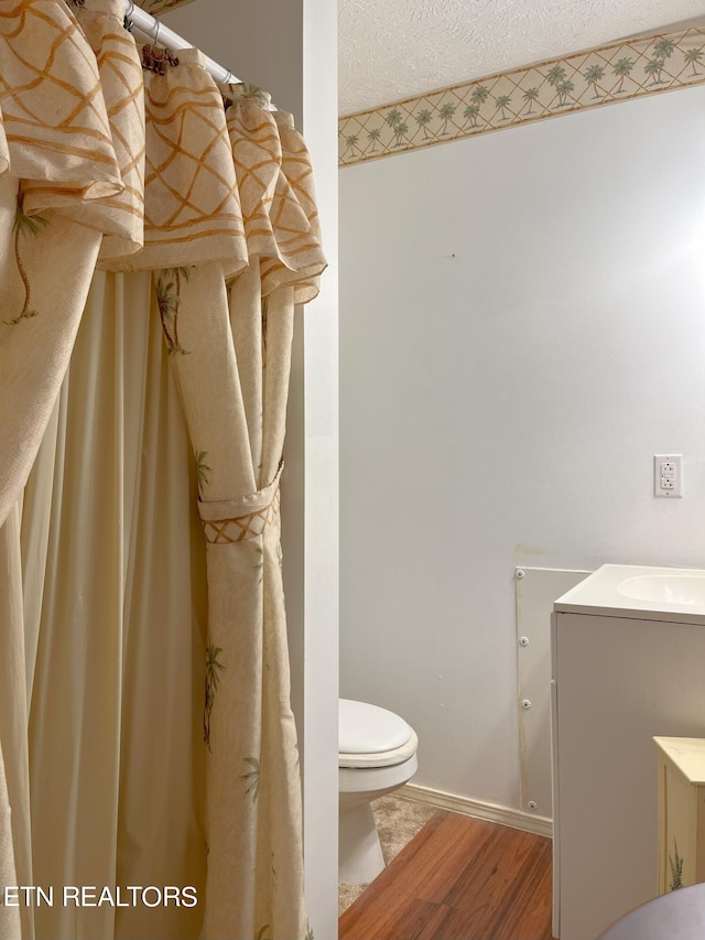 bathroom featuring hardwood / wood-style flooring, sink, a textured ceiling, and toilet