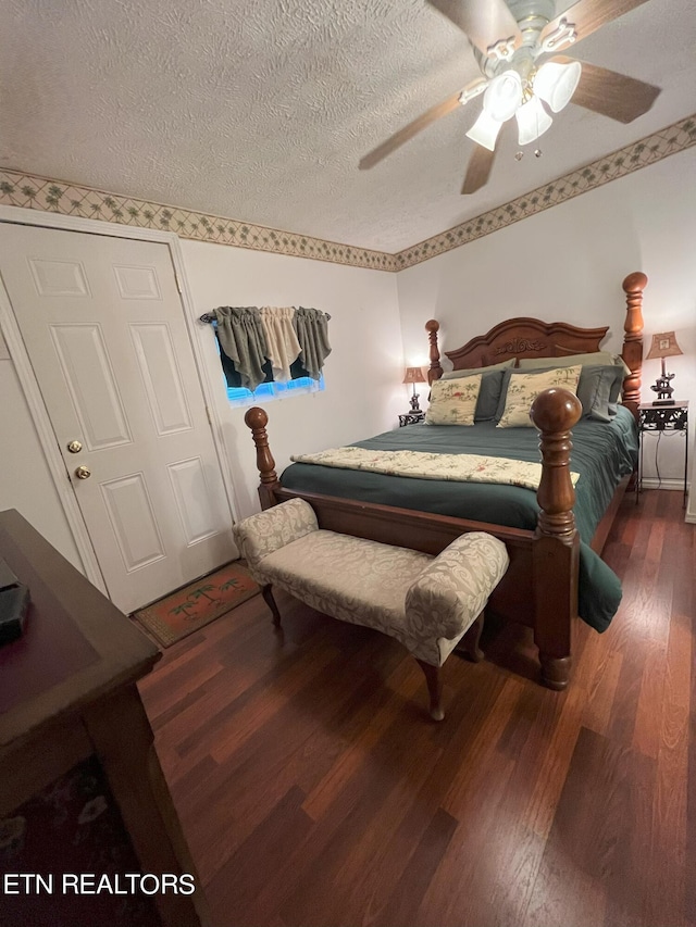 bedroom featuring ceiling fan, dark hardwood / wood-style floors, and a textured ceiling