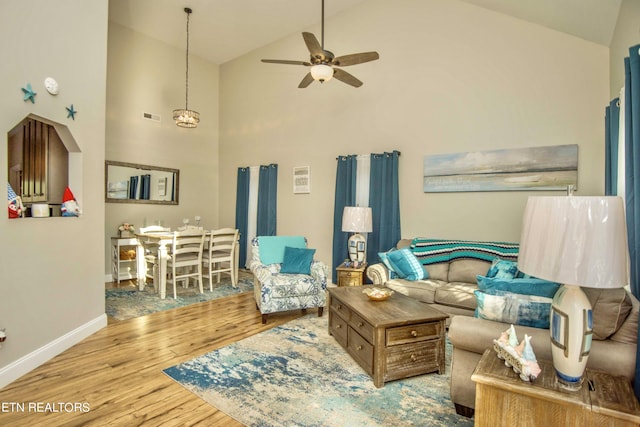 living room featuring ceiling fan, light hardwood / wood-style floors, and high vaulted ceiling