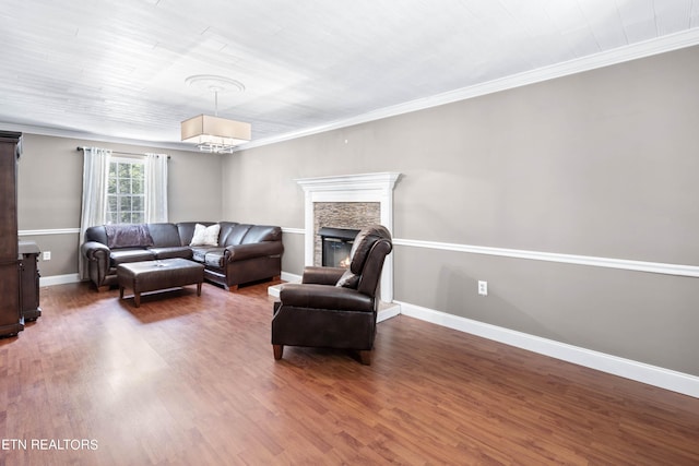 living room featuring a fireplace, dark wood-type flooring, and ornamental molding