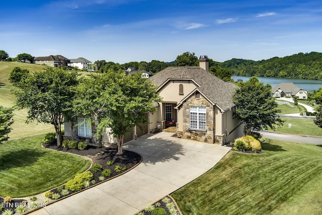 view of front of property with a garage, a water view, and a front yard