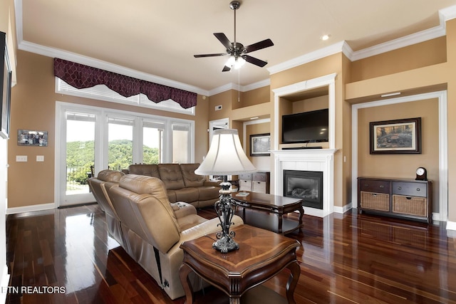 living room featuring a tiled fireplace, crown molding, dark hardwood / wood-style flooring, and ceiling fan