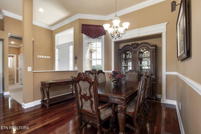 dining area featuring dark hardwood / wood-style flooring, crown molding, and an inviting chandelier